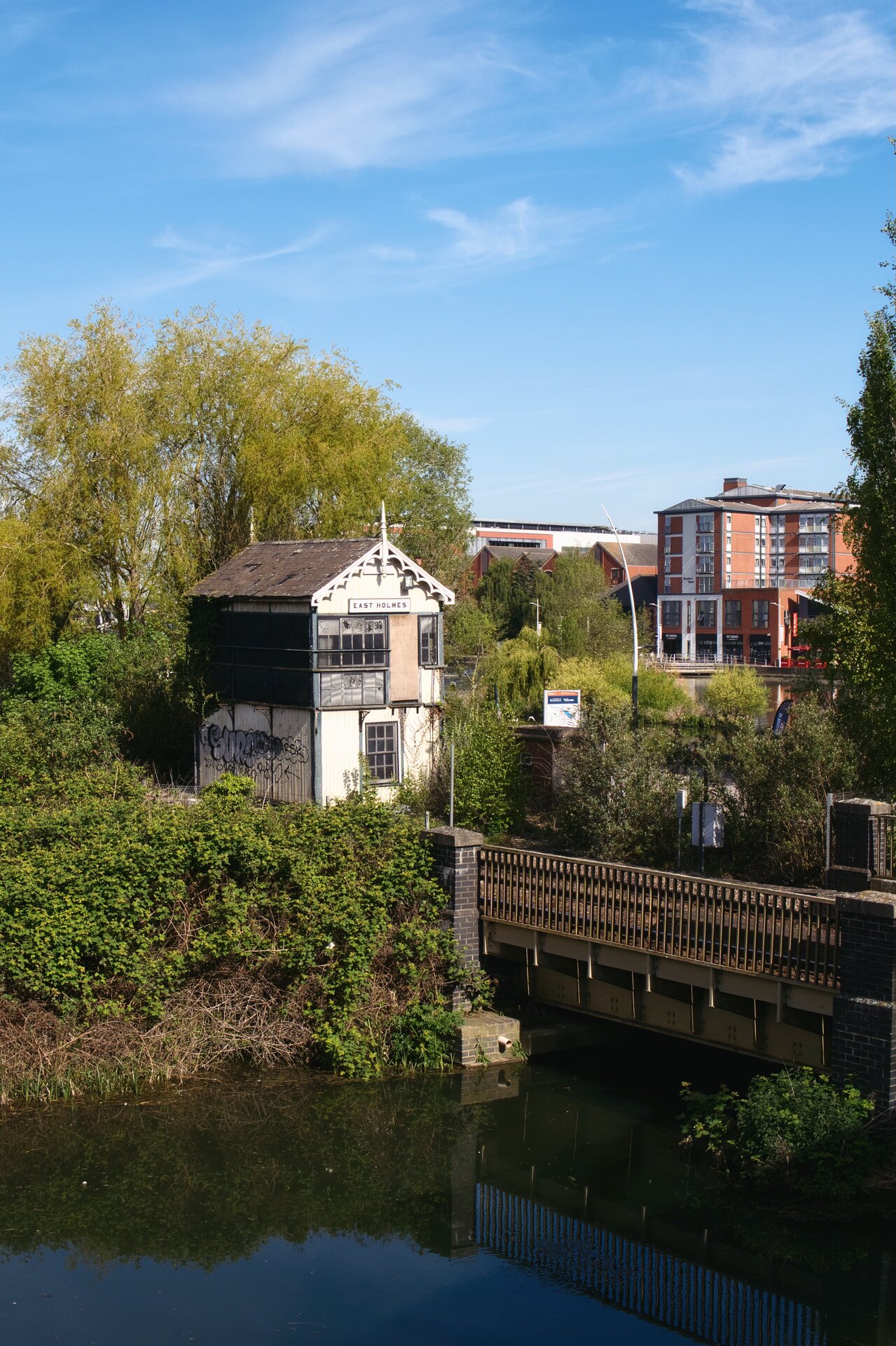 An old signal box building beside a canal and railway bridge
