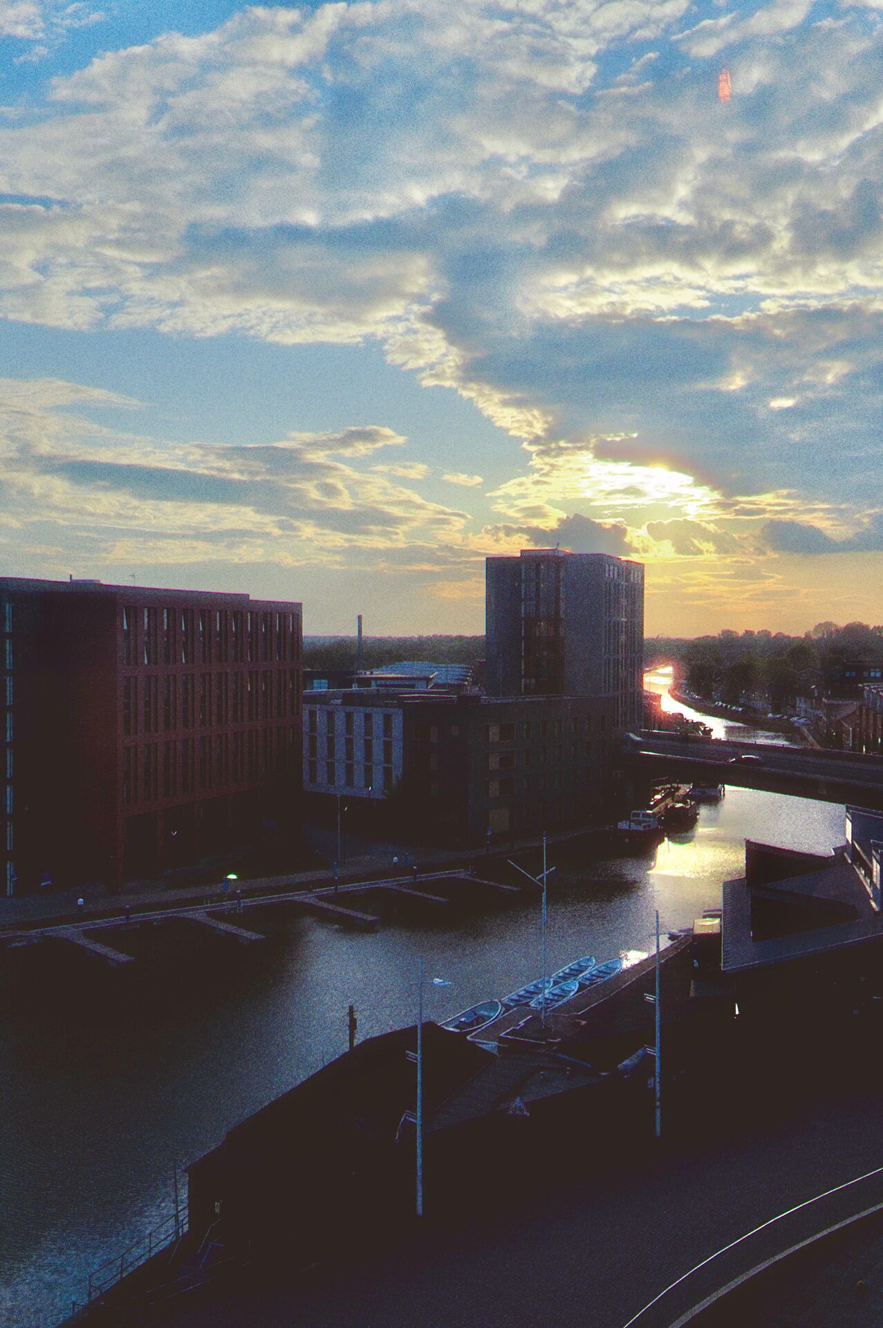 A city waterway at sunset with dramatic clouds overhead